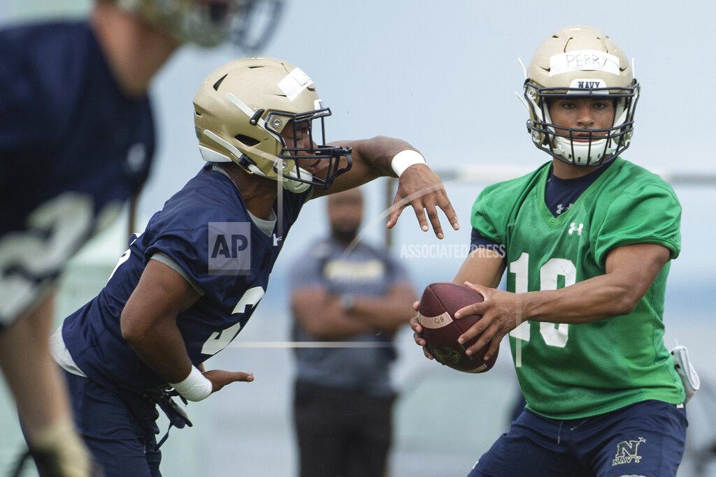 Tommy Gilligan FILE - In this Aug. 2, 2019, file photo, Navy quarterback Malcolm Perry, right, hands the ball off to fullback Jonathon Lee during NCAA college football training camp in Annapolis, Md. Niumatalolo has been especially pleased with the progress of senior quarterback Malcolm Perry. The Midshipmen spent the offseason implementing elements of the run and shoot, which features spread formations and relies on receivers to adjust their routes based on coverage. (AP Photo/Tommy Gilligan, File)