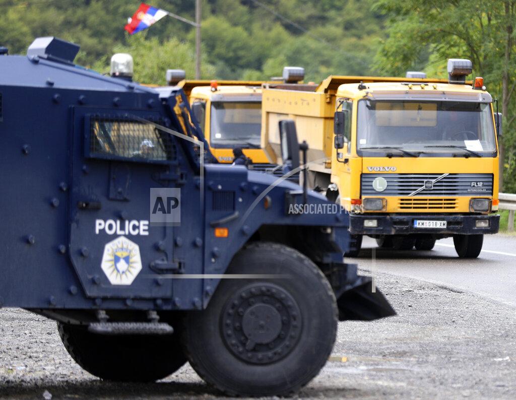 Bojan Slavkovic Kosovo special police with armored vehicle stand near trucks where Kosovo Serbs block a road near the northern Kosovo border crossing of Jarinje, Monday, Sept. 20, 2021. Tensions soared Monday at the border between Kosovo and Serbia as Kosovo deployed additional police to implement a rule to remove Serbian license plates from cars entering Kosovo, while Serbs protested the move. (AP Photo/Bojan Slavkovic)