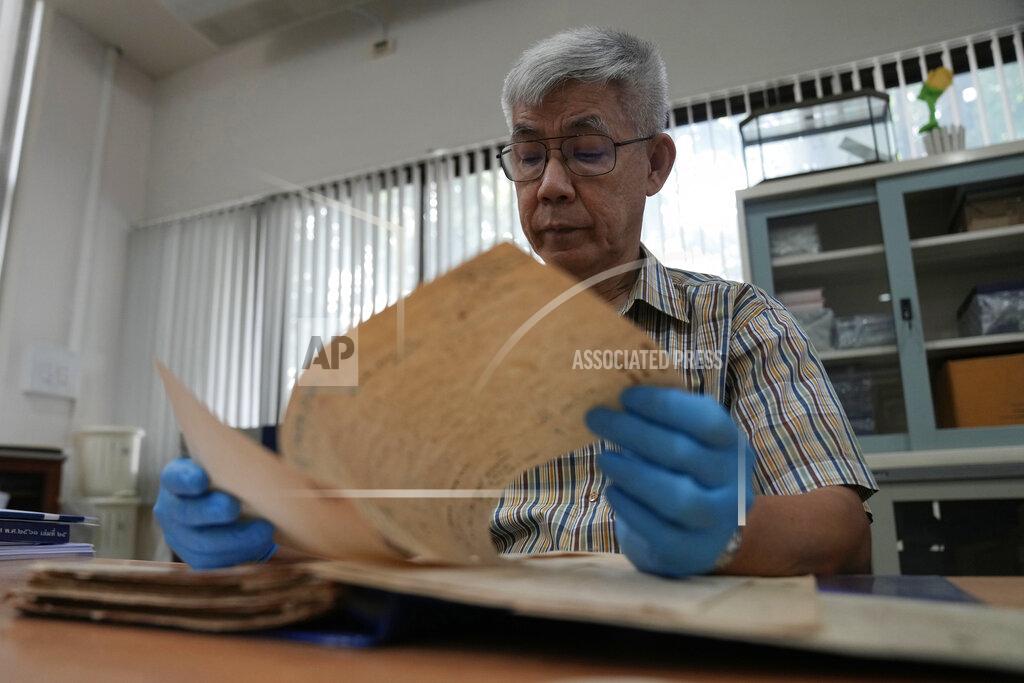 Sakchai Lalit Retired Thai Air Chief Marshal Sakpinit Promthep looks at a WWII-era local Thai police report in the archive room of the Thai Air Force Museum, In Bangkok, Thailand, Friday April 29, 2022. The document helped locate the possible remains of a U.S. pilot, missing from that time, from a crash site in Lampang province. documenting the crash of a U.S. P-38 plane. (AP Photo/Sakchai Lalit)