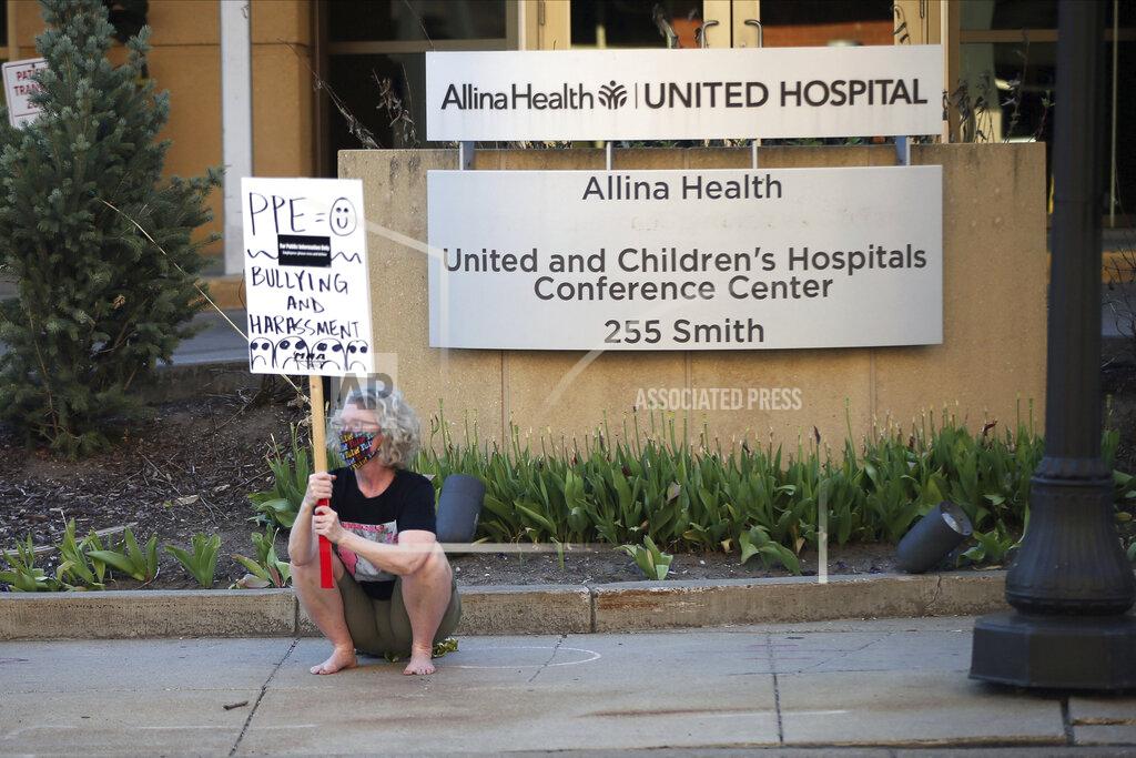 Jim Mone Nurses picket United Hospital, Wednesday, May 20, 2020, in St. Paul, Minn., as they seek a say in worker protections, increased personal protection resources with higher safety standards and an end to retaliation against workers who have tried to protect themselves from the coronavirus. (AP Photo/Jim Mone)