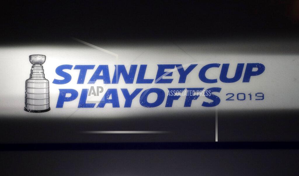 FILE - In this April 26, 2019, file photo, the Stanley Cup playoffs logo is seen on the ice during a light and sound check prior to Game 1 of an NHL hockey second-round playoff series between the New York Islanders and the Carolina Hurricanes, in New York. The NHL nailed down the final details of a playoff format if the season can resume on the same day word came out that another player has tested positive for the coronavirus.(AP Photo/Julio Cortez, File)