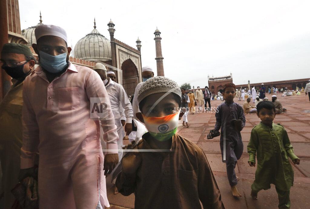 Manish Swarup An Indian Muslim boy wears a protective mask in the colors of the Indian national flag, leaves after offering Eid al-Adha prayer at the Jama Masjid in New Delhi, India, Saturday, Aug.1, 2020. Eid al-Adha, or the Feast of the Sacrifice, by sacrificing animals to commemorate the prophet Ibrahim's faith in being willing to sacrifice his son. (AP Photo/Manish Swarup)
