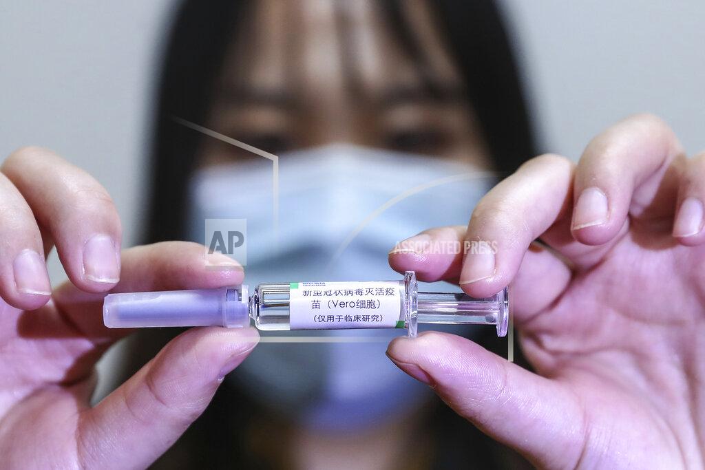 Zhang Yuwei In this April 10, 2020, photo released by Xinhua News Agency, a staff member holds up a sample of a potential COVID-19 vaccine at a production plant of SinoPharm in Beijing. In the global race to make a coronavirus vaccine, the state-owned Chinese company is boasting that it gave its employees, including top executives, experimental shots even before the government OK'd testing in people. (Zhang Yuwei/Xinhua via AP)