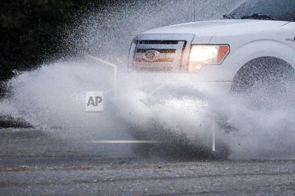 Butch Dill A vehicle travels along a flooded road as severe weather produces torrential rainfall, Tuesday, May 4, 2021 in Vestavia, Ala. (AP Photo/Butch Dill)