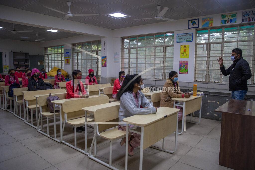 Altaf Qadri Students wearing face masks as a precaution against the coronavirus, attend classes as schools reopen after being closed for months due to the COVID-19 pandemic in New Delhi, India, Monday, Jan. 18, 2021. Delhi on Monday opened schools for students of grade 10 and 12 after a gap of more than nine months. (AP Photo/Altaf Qadri)