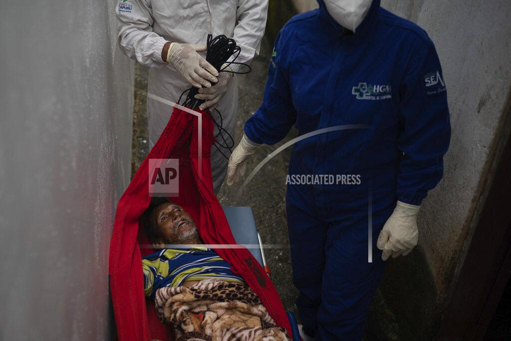 An emergency worker carries Jose Rocha on a hammock to a field hospital treating suspected COVID-19 patients in Manacapuru, Amazonas state, Brazil, Monday, June 1, 2020. Rocha was having difficulty breathing. (AP Photo/Felipe Dana)