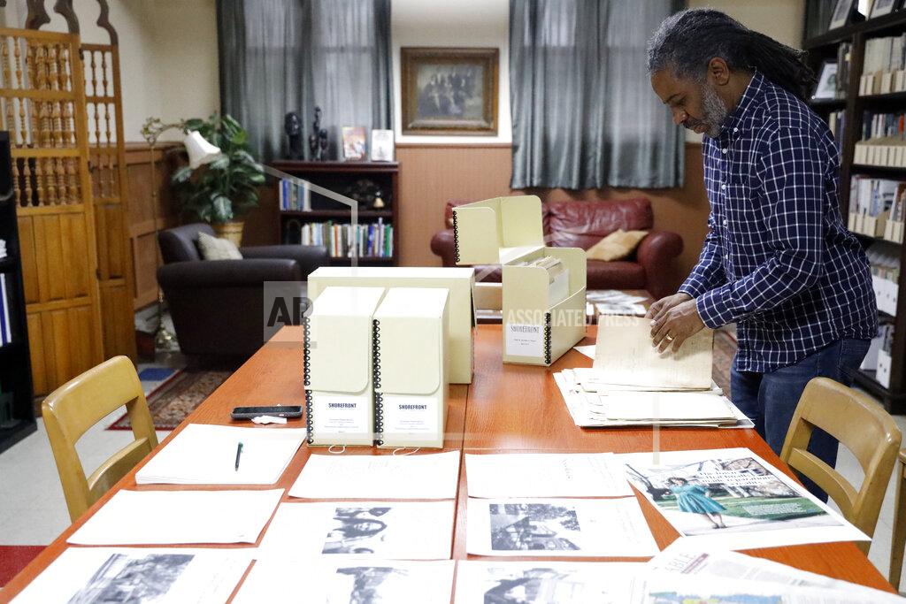 Shafkat Anowar Evanston's local historian Morris "Dino" Robinson Jr., scrolls through the archives in Shorefront Legacy Center in Evanston, Ill., Friday, April 9, 2021. The Chicago suburb is preparing to pay reparations in the form of housing grants to Black residents who experienced housing discrimination. “It’s a lot, a lot of work, and be prepared for pulling back old wounds, telling truth, gaining the trust,” said Robinson, who co-authored a city-commissioned study on housing practices. (AP Photo/Shafkat Anowar)