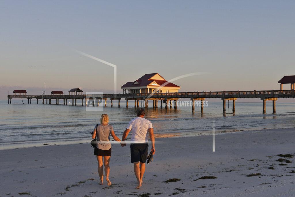 Chris O'meara A couple walk hand in hand on Clearwater Beach soon after it was reopened to the public Monday, May 4, 2020, in Clearwater Beach, Fla. Many public beaches and restaurants are reopening as part of Florida Gov. Ron DeSantis' phase one to stop the spread of the coronavirus. (AP Photo/Chris O'Meara)