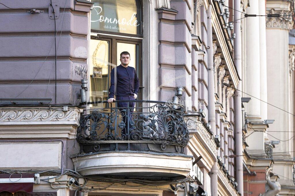 Dmitri Lovetsky Mikhail Kavin, manager of the Commode bar stands on the balcony of his bar in St. Petersburg, Russia, Wednesday, March 24, 2021. Police raided the bar in December for serving customers behind closed doors past 11 p.m. in violation of coronavirus restrictions. Even with flouting the rules, it hasn't bounced back to its pre-pandemic level of sales, Kavin said. (AP Photo/Dmitri Lovetsky)
