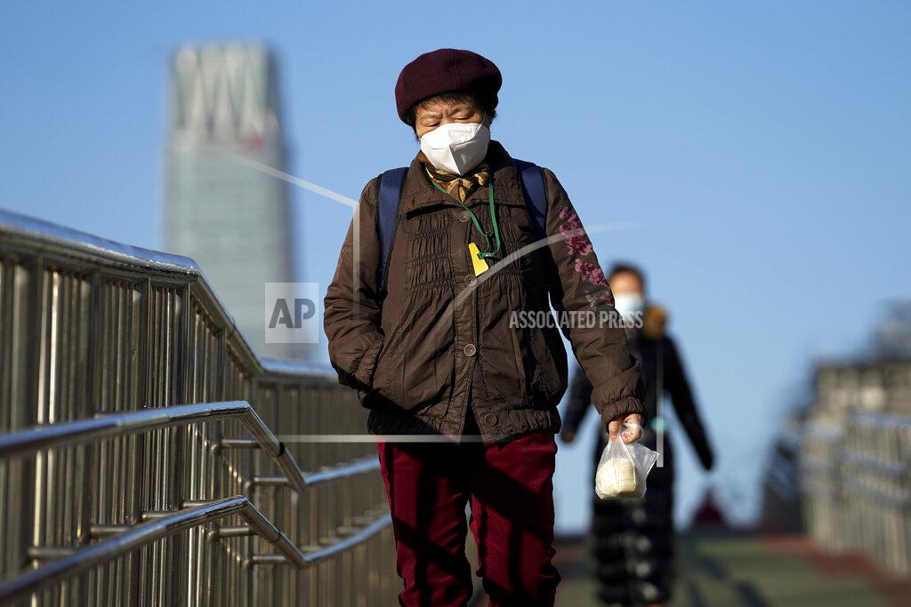Andy Wong Women wearing face masks to help curb the spread of the coronavirus walk along a pedestrian bridge in Beijing, Monday, Nov. 30, 2020. (AP Photo/Andy Wong)