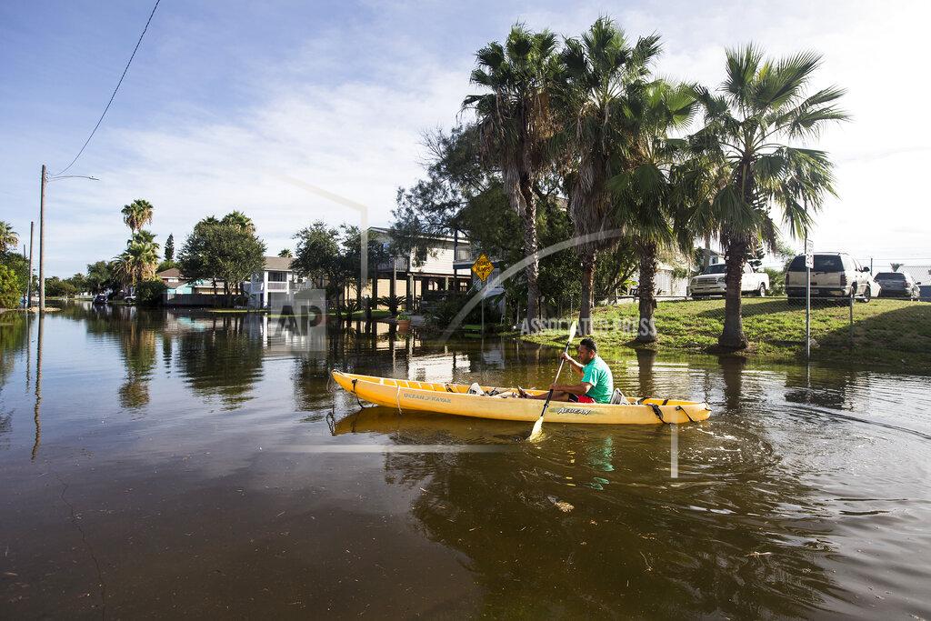 Brett Coomer Martin Almanza paddles a canoe through some street flooding following landfall of Hurricane Laura on Thursday, Aug. 27, 2020 in Galveston, Texas. (Brett Coomer/Houston Chronicle via AP)
