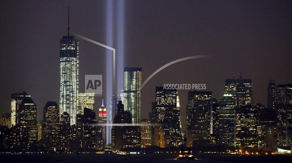 FILE - In this Wednesday, Sept. 11, 2013, file photo, the twin beams of the annual Tribute in Light commemorating the Sept. 11, 2001, terrorist attacks shine amid the city's skyline, in New York. The twin beams of light representing the World Trade Center towers won’t be beamed into the sky during the 2020 memorial of the 9/11 terror attacks in New York City, because of concerns about the coronavirus and the health of work crews. (AP Photo/Kathy Willens, File)