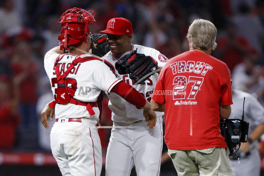 Alex Gallardo Los Angeles Angels relief pitcher Raisel Iglesias, center, hugs catcher Max Stassi after the Angels defeated the New York Yankees 6-4 in a baseball game in Anaheim, Calif., Tuesday, Aug. 31, 2021. (AP Photo/Alex Gallardo)