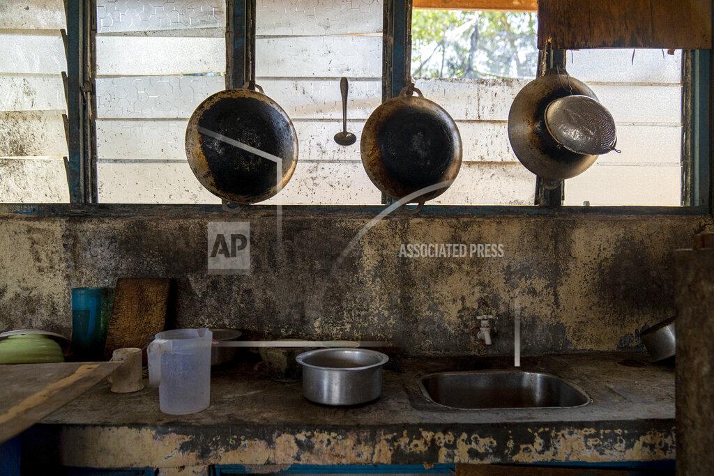 Ore Huiying Pots and pans hang in the kitchen of workers' living quarters in a palm oil plantation run by the government-owned Felda in Malaysia in early 2020. Jum, a former worker who escaped from this same plantation, said the company confiscated, and later lost his Indonesian passport, leaving him vulnerable to arrest and forcing him to hide in the jungle. (AP Photo/Ore Huiying)