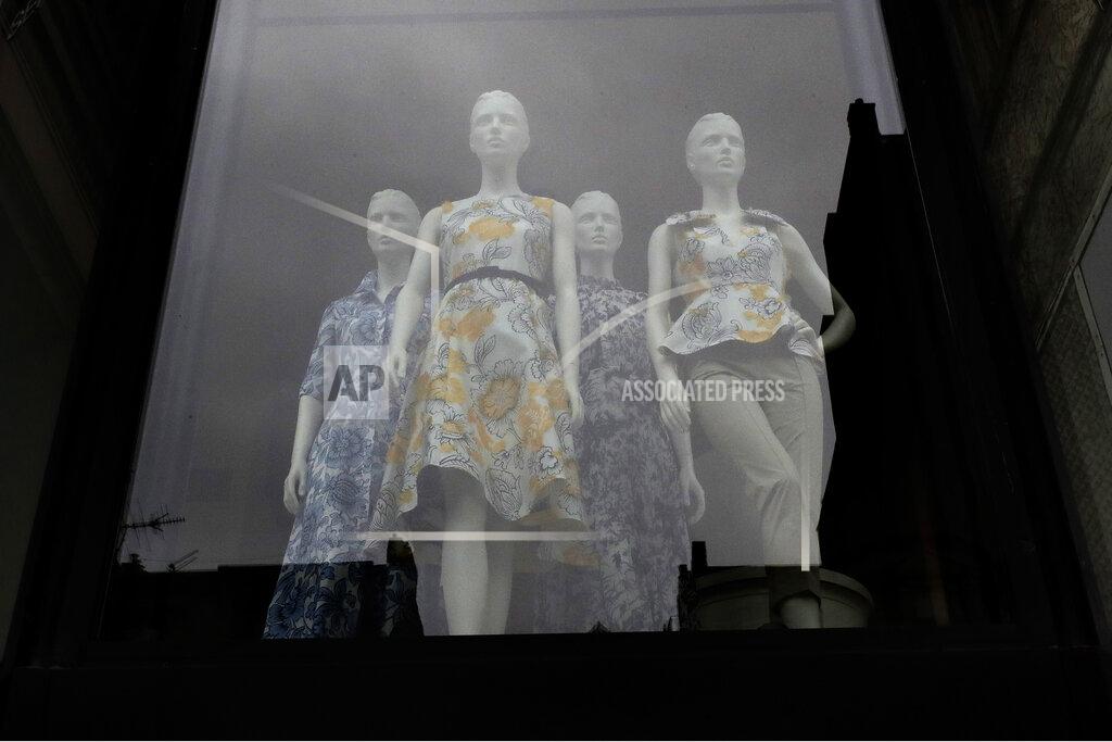 Steven Senne FILE - In this June 11, 2020, file photo garments are displayed on mannequins in a storefront window in Boston. Eighty-five percent of Democrats call economic conditions “poor,” while 65% of Republicans describe them as “good,” according to a new survey by The Associated Press-NORC Center for Public Affairs Research. (AP Photo/Steven Senne, File)