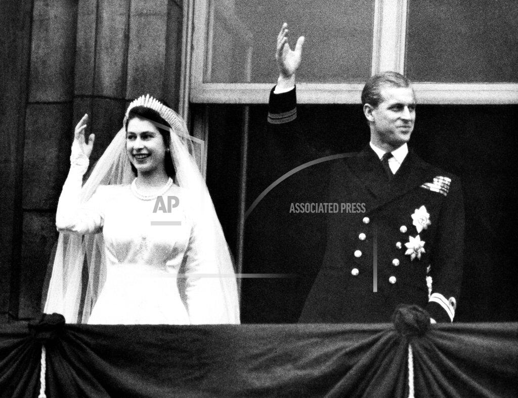 Uncredited FILE - In this Nov. 20, 1947 file photo, Britain's Princess Elizabeth and her husband the Duke of Edinburgh wave to the crowds on their wedding day, from the balcony of Buckingham Palace in London. In 1947. Philip married Britain’s Princess Elizabeth, the elder daughter of King George VI, and when she became queen at the age of 25 in 1952, Philip gave up his naval career and dedicated himself to supporting her and the monarchy. Prince Philip who died Friday April 9, 2021, aged 99, lived through a tumultuous century of war and upheavals. (AP Photo/File)