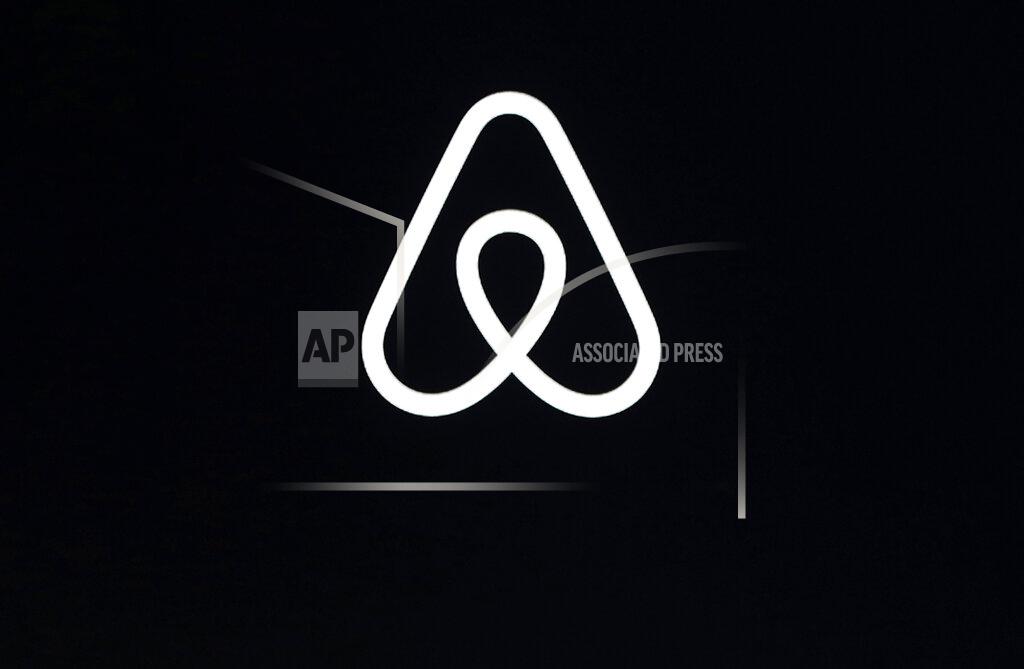 FILE - This Feb. 22, 2018, file photo shows an Airbnb logo during an event in San Francisco. Home-sharing site Airbnb posted a $3.9 billion loss in the fourth quarter of 2020 as it suffered from the pandemic downturn in travel and recorded one-time costs for becoming a public company. (AP Photo/Eric Risberg, File)
