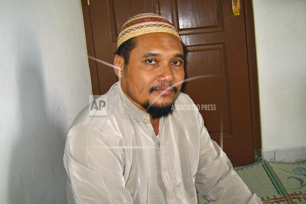 Chris Brummitt FILE - In this March 16, 2007 file photo, militant cleric Abu Rusdan sits in his family home during an interview with The Associated Press in Kudus, Central Java, Indonesia. Indonesia's elite counterterrorism squad has arrested the convicted militant and suspected leader of an al-Qaida-linked group that has been blamed for a string of past bombings in the country, Indonesia police said Monday, Sept. 13, 2021. (AP Photo/Chris Brummitt, File)