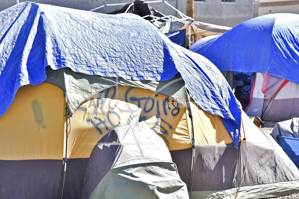 Steve Carr Tents for homeless at the Lots in downtown Phoenix have tarps or blankets draped over them on June 24, 2020, for an added layer of relief from the heat. Homeless people are among the most vulnerable populations in the COVID-19 pandemic, yet they're largely invisible victims. Very little is known about how they're faring. The U.S. Department of Housing and Urban Development, which oversees homeless programs, has not required its national network of providers to gather infection or death data, even though homeless people, unlike other high-risk groups such as nursing home residents, interact more with the public. (Steve Carr/Human Services Campus and the Howard Center For Investigative Journalism via AP)