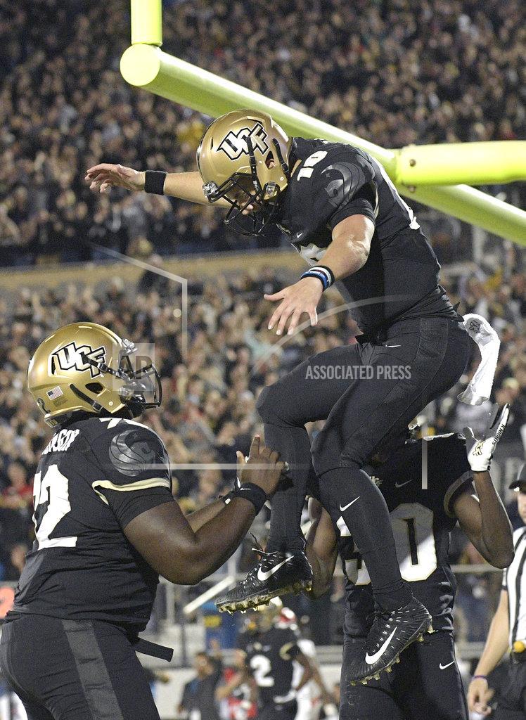 Phelan M. Ebenhack Central Florida quarterback McKenzie Milton (10) celebrates with offensive lineman Jordan Johnson (72) and running back Greg McCrae (30) after Milton rushed for a 3-yard touchdown during the first half of an NCAA college football game against Cincinnati on Saturday, Nov. 17, 2018, in Orlando, Fla. (AP Photo/Phelan M. Ebenhack)