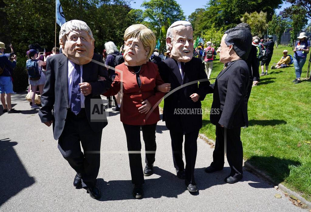 Alberto Pezzali Activists dressed in giant papier-mache heads depicting G7 leaders participate in a march during a demonstration around the meeting of the G7 in Falmouth, Cornwall, England, Saturday, June 12, 2021. Leaders of the G7 gather for a second day of meetings on Saturday, in which they will discuss COVID-19, climate, foreign policy and the economy. (AP Photo/Alberto Pezzali)