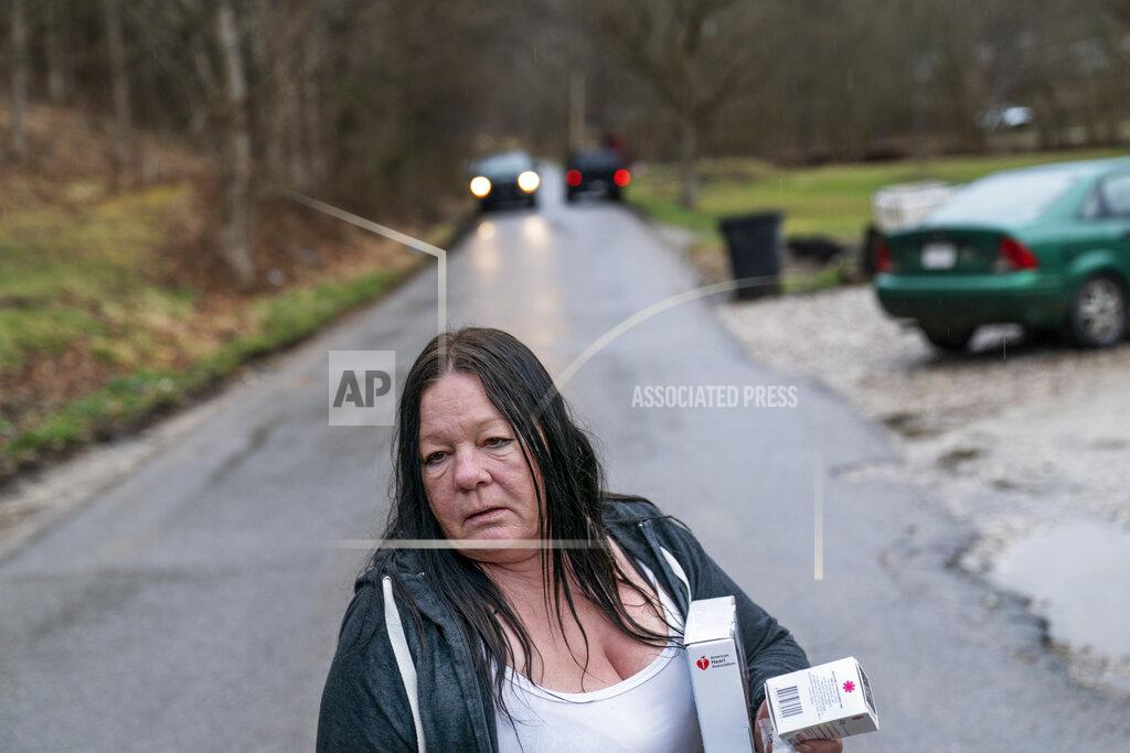 David Goldman Yvonne Ash carries back to her house a CPR kit and a supply of the overdose reversal medication naloxone after a visit from the Quick Response team, which visits everyone who overdoses to offer help, Monday, March 15, 2021, in Branchland, W.Va., just days after Ash's son overdosed, "We need help," Ash said. People have been dying all around her. Her nephew. Her neighbors. Then, almost her son. "People I've known all my life since I was born, it takes both hands count them," she said. "In the last six months, they're gone." (AP Photo/David Goldman)