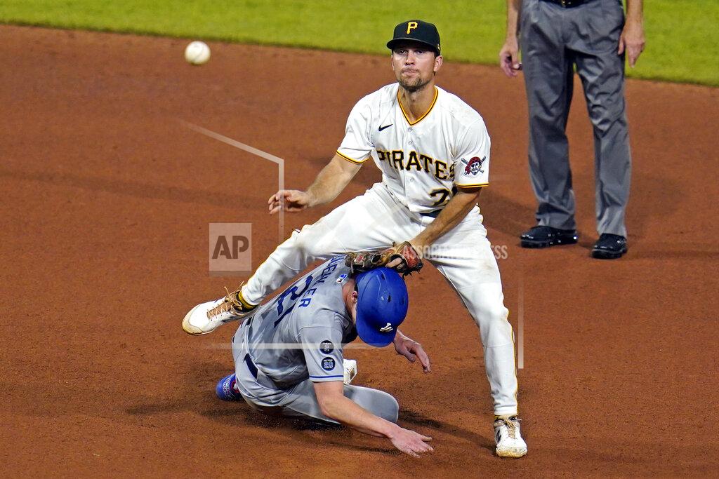 Gene J. Puskar Pittsburgh Pirates second baseman Adam Frazier, top, makes the throw to first as he steps over Los Angeles Dodgers' Walker Buehler, after getting the force at second, to complete a double play on Mookie Betts during the seventh inning of a baseball game in Pittsburgh, Tuesday, June 8, 2021. (AP Photo/Gene J. Puskar)