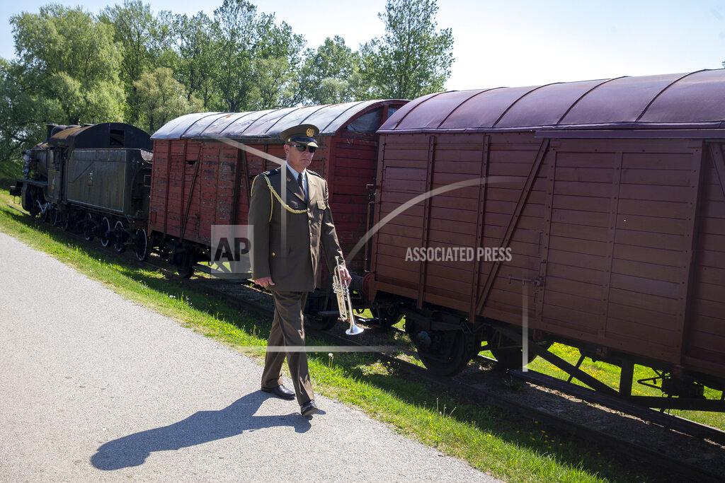 Darko Bandic A military trumpet player walks past a train used to transport inmates, after a commemoration ceremony for the victims of a World War II camp in Jasenovac, Croatia, Wednesday, April 22, 2020. Representatives of the Croatian Jews, Serbs, Roma and anti-fascists for the first time in years agreed to join top Croatian officials at the ceremony, but warned this was because of the emergency situation over the new coronavirus and could change unless the authorities do more to curb right-wing sentiments in the country. (AP Photo/Darko Bandic)