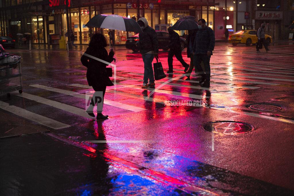 Mark Lennihan Shoppers walk in a rainstorm, Monday, Nov. 30, 2020 in New York. With people staying home as virus cases surge, Cyber Monday is expected to be the biggest online shopping day yet, bringing in nearly $13 billion in one day. (AP Photo/Mark Lennihan)