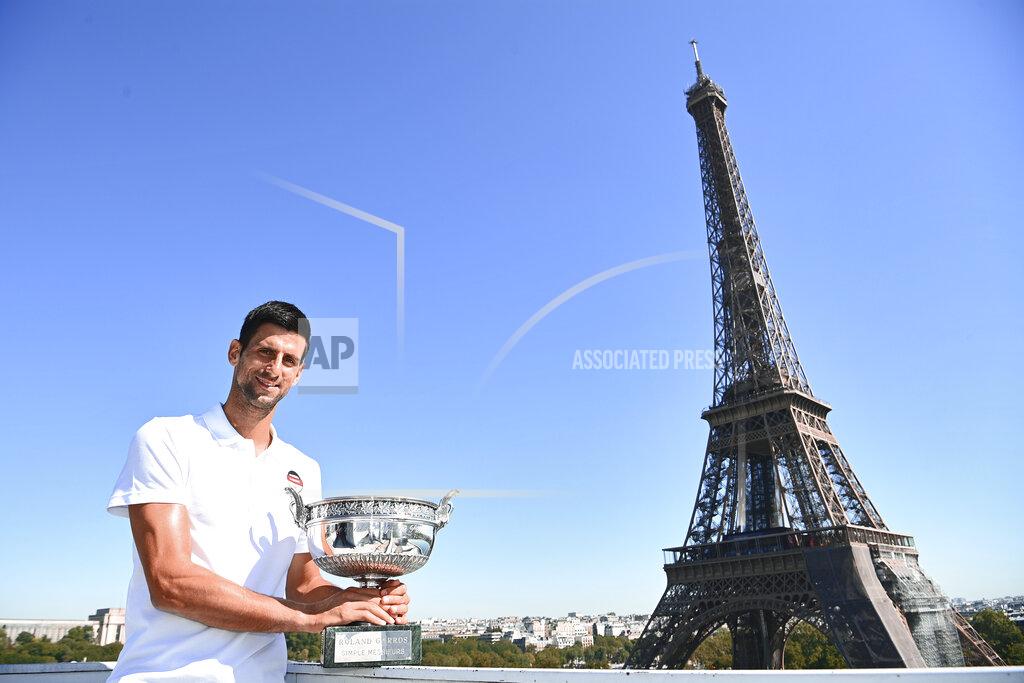 Serbia's Novak Djokovic poses with the trophy in front of the Eiffel tower during a photocall, Monday, June 14, 2021 in Paris, one day after winning French Open tennis tournament against Stefanos Tsitsipas of Greece. (Christophe Archanbault, Pool via AP)