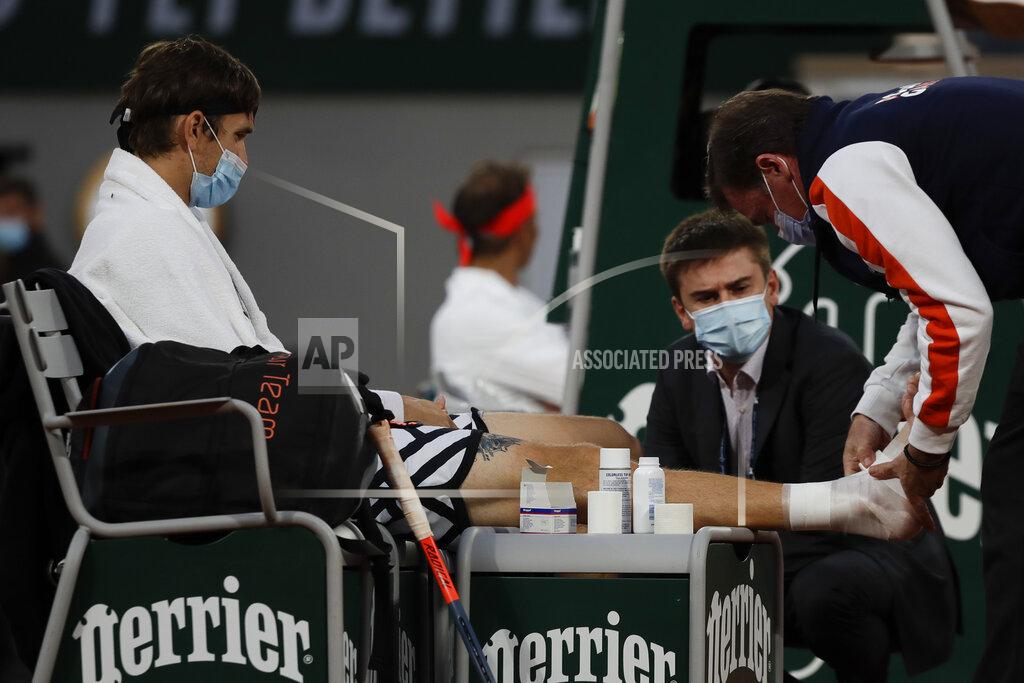 Alessandra Tarantino Egor Gerasimov of Belarus is treated for an ankle injury in the first round match of the French Open tennis tournament against Spain's Rafael Nadal at the Roland Garros stadium in Paris, France, Monday, Sept. 28, 2020. (AP Photo/Alessandra Tarantino)