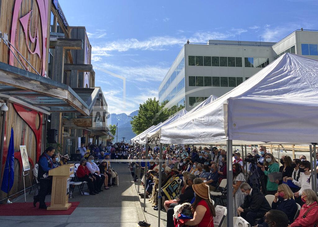 Becky Bohrer People gather for a ceremony that marked the release of the Raven Story stamp Friday, July 30, 2021 in downtown Juneau, Alaska. The stamp, issued by the U.S. Postal Service, was created by Alaska Native artist Rico Worl. (AP Photo/Becky Bohrer)