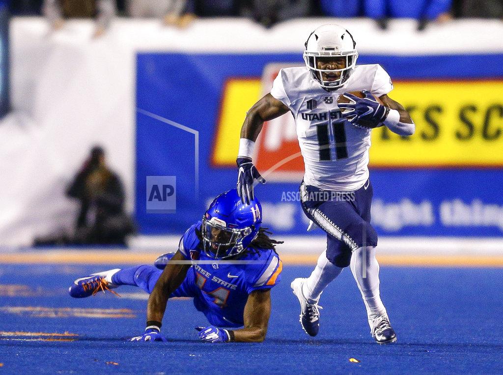 Steve Conner Utah State wide receiver Aaren Vaughns (11) runs past a diving Boise State cornerback Tyler Horton (14) during the first half of an NCAA college football game Saturday, Nov. 24, 2018, in Boise, Idaho. (AP Photo/Steve Conner)