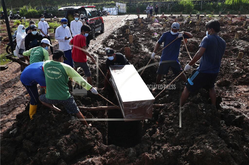 Tatan Syuflana Workers lower a coffin into a grave during a burial at the special section of Jombang Public Cemetery reserved for those who died of COVID-19, in Tangerang on the outskirts of Jakarta, Indonesia, Monday, June 21, 2021. Indonesia saw significant spikes in confirmed COVID-19 cases recently, an increase blamed on travel during last month's Eid al-Fitr holiday as well as the arrival of new virus variants, such as the the Delta version first found in India. (AP Photo/Tatan Syuflana)