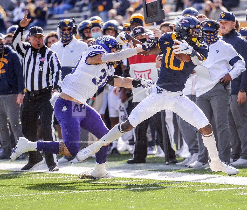 William Wotring West Virginia wide receiver Sean Ryan (10) is pushed out of bounds by TCU linebacker Garret Wallow (30) during the first half of an NCAA college football game on Saturday, Nov. 14, 2020, in Morgantown, W.Va. (William Wotring/The Dominion-Post via AP)