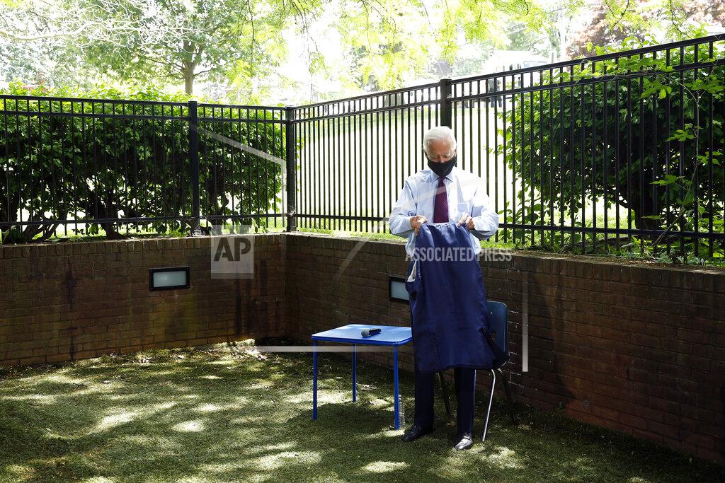 Matt Slocum Democratic presidential candidate, former Vice President Joe Biden folds his coat as he arrives to speak with families who have benefited from the Affordable Care Act, Thursday, June 25, 2020, in Lancaster, Pa. (AP Photo/Matt Slocum)