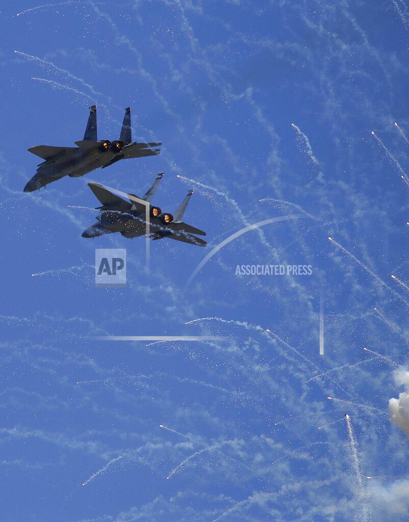 Ben Margot F-15C Eagles from the 123rd Fighter Squadron of the Oregon National Guard fly over fireworks during the national anthem prior to a NASCAR Sprint Cup Series auto race Sunday, June 23, 2019, in Sonoma, Calif. (AP Photo/Ben Margot)