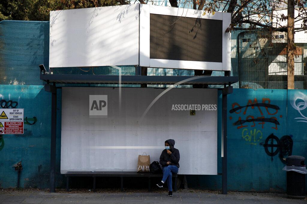 Petros Karadjias A woman wearing a face mask sits at a bus stop in central capital Nicosia, Cyprus, Friday, Jan. 8, 2021. Cyprus is returning to lockdown mode for the remainder of the month with daytime restrictions on movement and a shuttering of schools after the country's health minister conceded that a raft of tough measures already in place including a night-time curfew weren't enough to curtail the spread of the coronavirus. (AP Photo/Petros Karadjias)