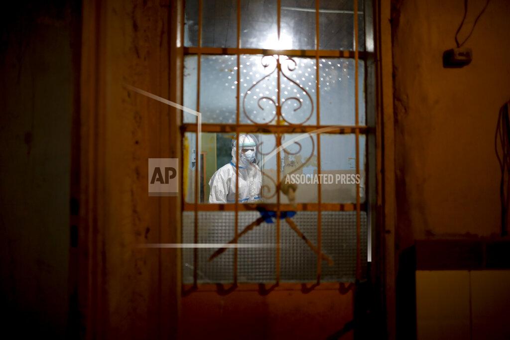 Natacha Pisarenko Ambulance Doctor Vladimir Canal enters a home to attend a COVID-19 patient with oxygen problems after an emergency call to the residence during his night shift in Lomas de Zamora, Argentina, late Thursday, June 10, 2021. (AP Photo/Natacha Pisarenko)