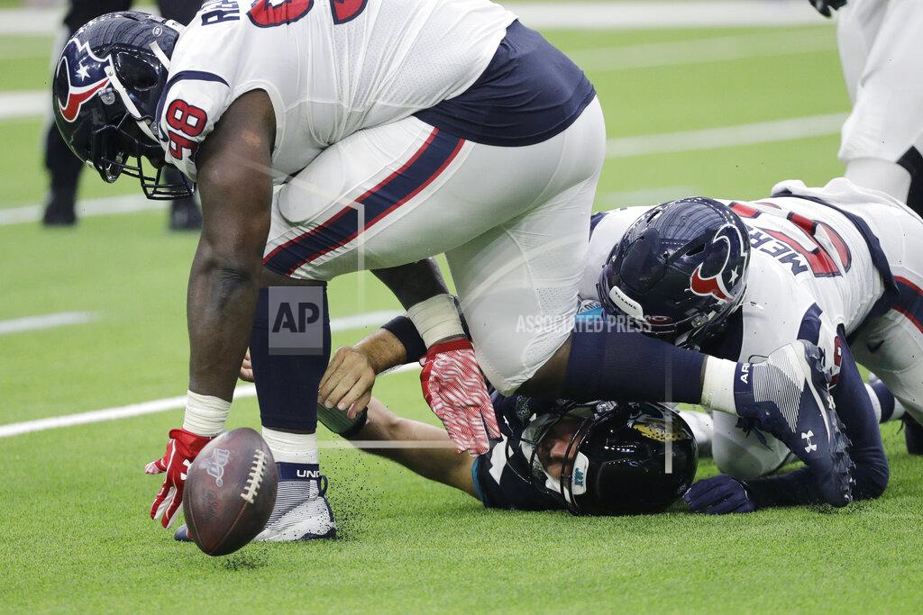 David J. Phillip Jacksonville Jaguars quarterback Gardner Minshew (15) fumbles as he is hit by Houston Texans outside linebacker Whitney Mercilus (59) and defensive end D.J. Reader (98) during the first half of an NFL football game Sunday, Sept. 15, 2019, in Houston. (AP Photo/David J. Phillip)