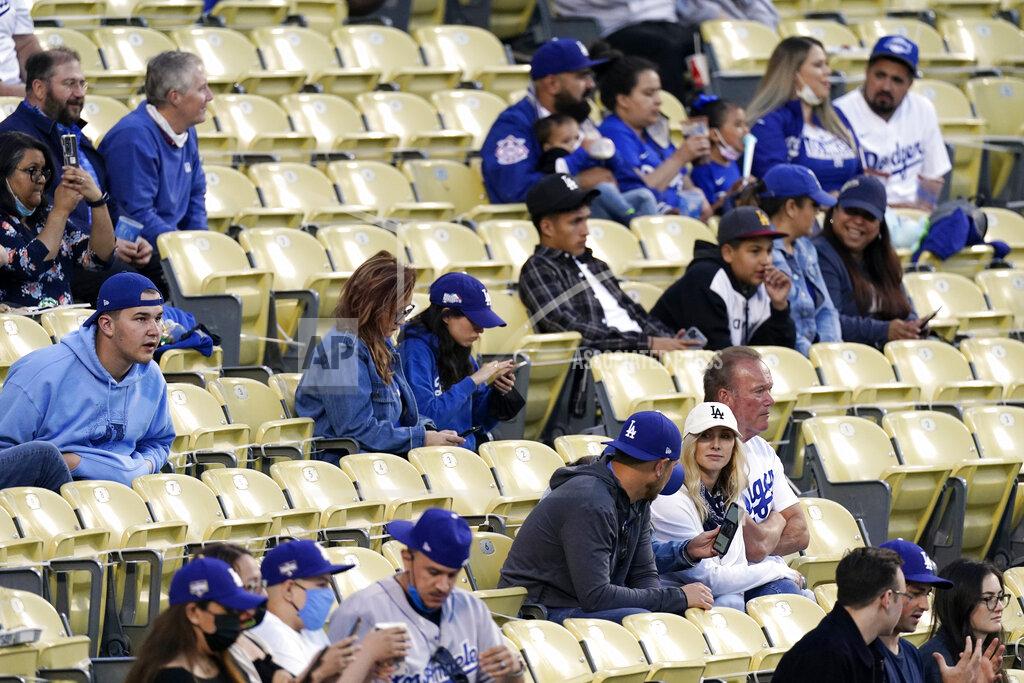 Mark J. Terrill FILE - In this Friday, May 14, 2021, file photo, several fans are seen without masks as they watch the Miami Marlins play the Los Angeles Dodgers in a baseball game in Los Angeles. California's top health official says the state will no longer require social distancing and will allow full capacity for businesses when the state reopens on June 15. State health director Dr. Mark Ghaly said Friday, May 21, that dramatically lower virus cases and increasing vaccinations mean it's safe for the state to remove nearly all restrictions next month. (AP Photo/Mark J. Terrill, File)