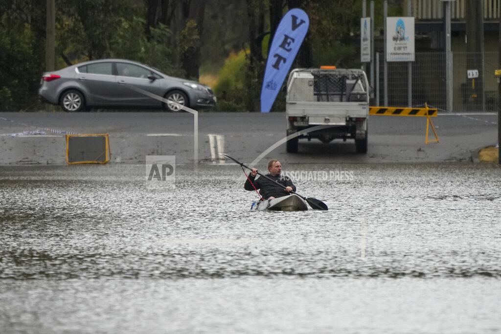 Mark Baker A man paddles his kayak through a flooded street at Windsor on the outskirts of Sydney, Australia, Tuesday, July 5, 2022. Hundreds of homes have been inundated in and around Australia's largest city in a flood emergency that was impacting 50,000 people, officials said Tuesday. (AP Photo/Mark Baker)