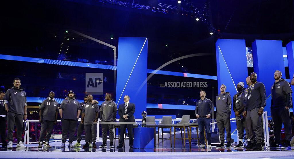 Matt Rourke Los Angeles Rams and New England Patriots team members line up on stage during Opening Night for the NFL Super Bowl 53 football game Monday, Jan. 28, 2019, in Atlanta. (AP Photo/Matt Rourke)