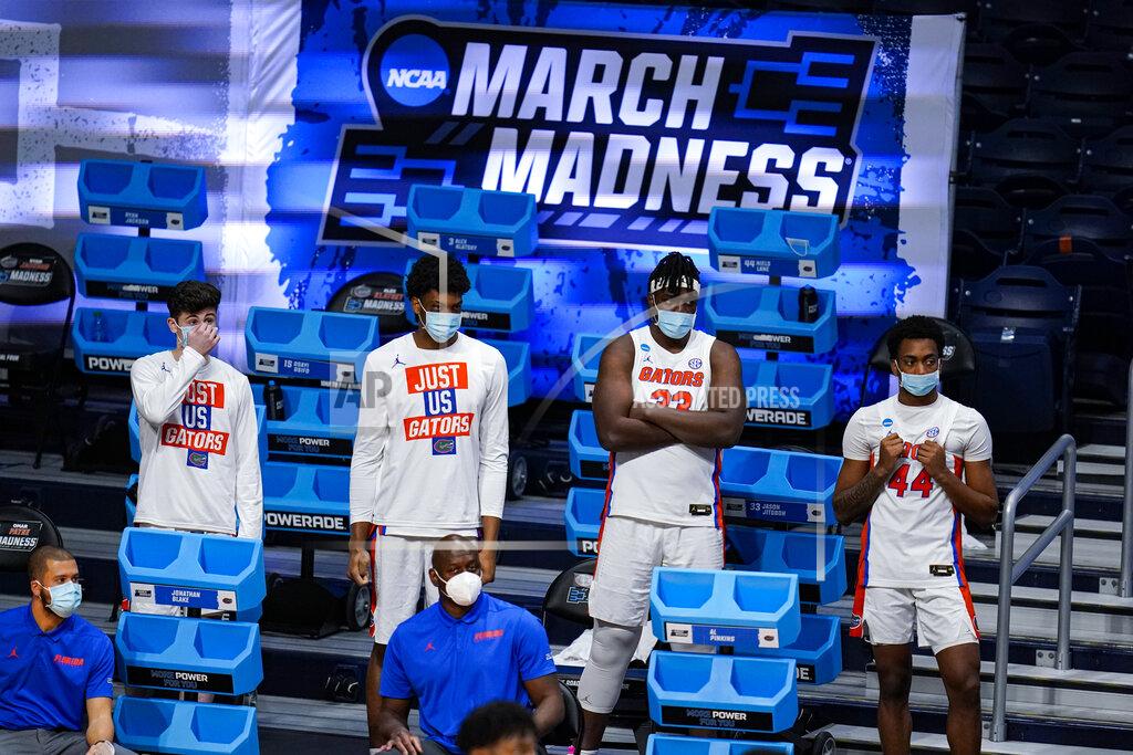 Michael Conroy Members of the Florida team, including Jason Jitoboh (33) and Niels Lane (44) watch from the bench in masks in the second half of a first round game against Virginia Tech in the NCAA men's college basketball tournament at Hinkle Fieldhouse in Indianapolis, Friday, March 19, 2021. Restrictions due to the COVID-19 pandemic have limited crowds, reduced interactions and created an abnormal NCAA experience for those involved. It’s sacrifices they’ve all been asked to make by the NCAA to pull off a tournament in the midst of the ongoing pandemic. (AP Photo/Michael Conroy)