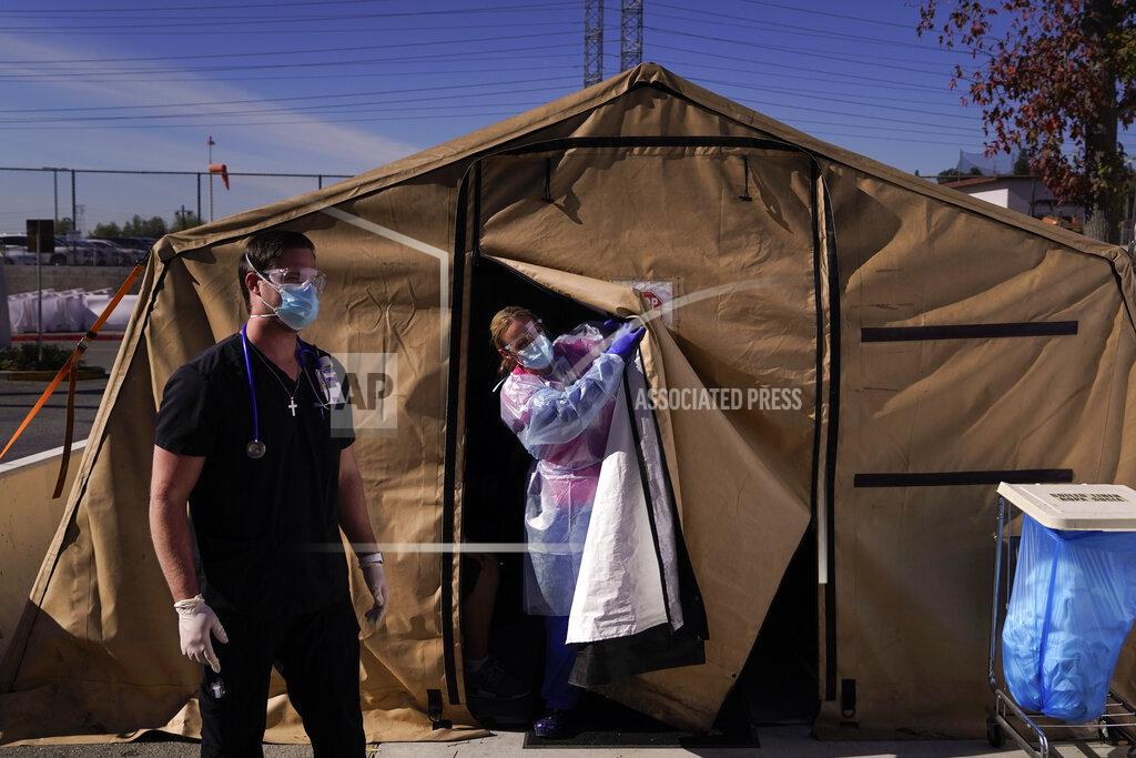 Jae C. Hong FILE - In this Dec. 22, 2020, file photo, registered nurse Keith Robinson, right, watches as fellow nurse Angela Coomds calls out a patient's name from a COVID-19 triage tent at Providence Holy Cross Medical Center in the Mission Hills section of Los Angeles. The U.S. death toll from COVID-19 has topped 500,000 — a number so staggering that a top health researchers says it is hard to imagine an American who hasn't lost a relative or doesn't know someone who died. (AP Photo/Jae C. Hong, File)