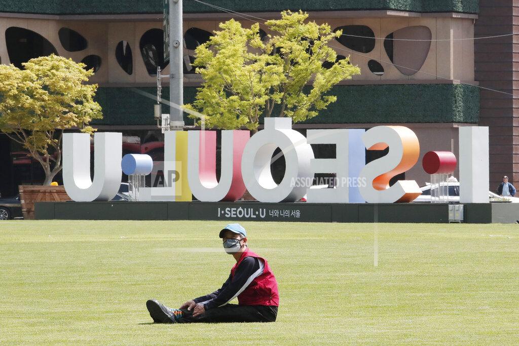 Ahn Young-Joon A man wearing a face mask to help protect against the spread of the new coronavirus takes a rest on the grass at Seoul Plaza in Seoul, South Korea, Thursday, May 21, 2020. (AP Photo/Ahn Young-joon)