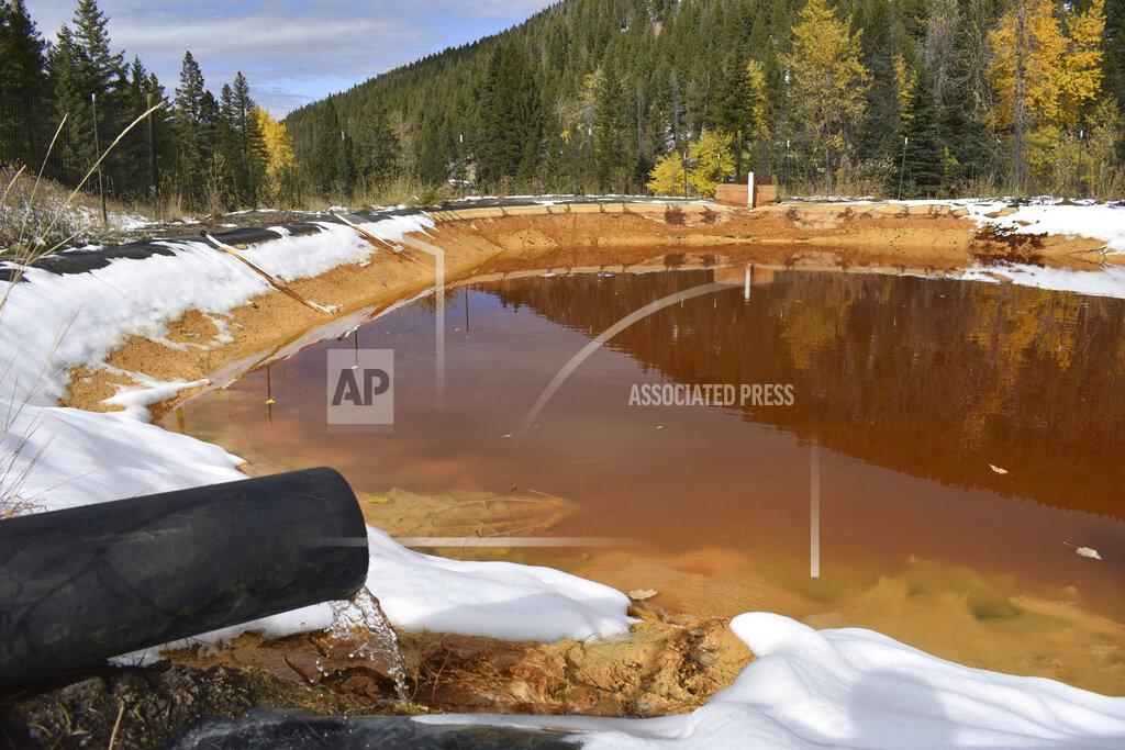 Matthew Brown FILE - In this Oct. 12, 2018, file photo, water contaminated with arsenic, lead and zinc flows from a pipe out of the Lee Mountain mine and into a holding pond near Rimini, Mont. President Joe Biden's $2.3 trillion plan to transform America’s infrastructure includes $16 billion to plug old oil and gas wells and clean up abandoned mines, a longtime priority for Western and rural lawmakers from both parties. (AP Photo/Matthew Brown, File)