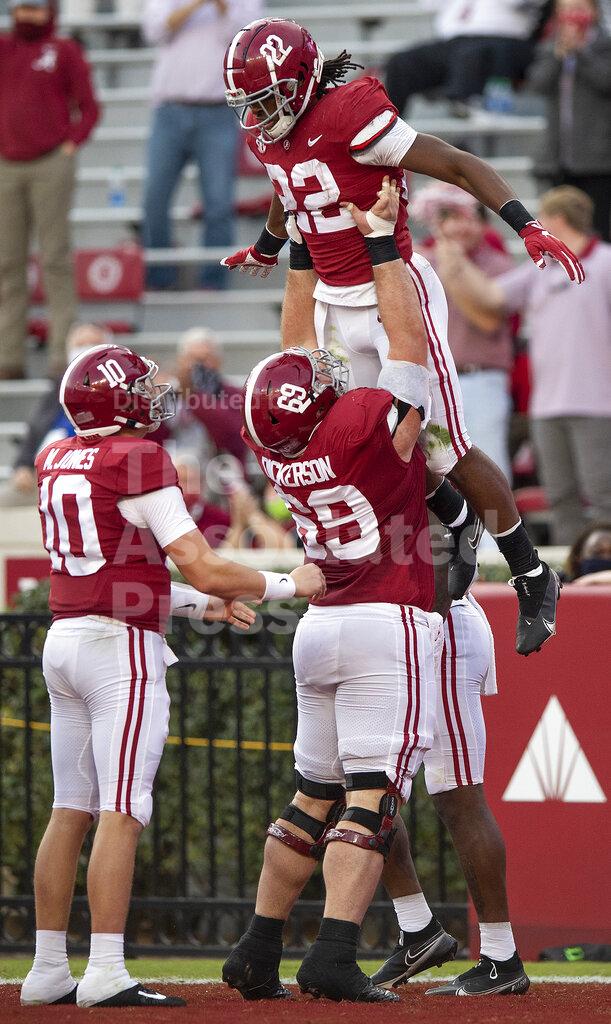 FILE - Alabama running back Najee Harris (22) is lifted by offensive lineman Landon Dickerson (69) after scoring against Kentucky during an NCAA college football game at Bryant-Denny Stadium in Tuscaloosa, Ala., in this Saturday, Nov. 21, 2020, file photo. Landon Dickerson plays multiple roles for Alabama. While he is an anchor on the Crimson Tide’s powerful offensive line, he also is a somewhat of an entertainer. His animated antics are a hit with teammates and fans. (Mickey Welsh/The Montgomery Advertiser via AP, File)