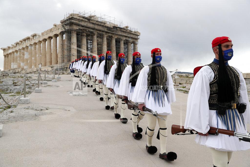 Petros Giannakouris Members of the Presidential Guard walk in front of the Parthenon temple atop of Acropolis Hill after the Greek flag raising ceremony in Athens, Thursday, March 25, 2021. Greece celebrates the bicentenary of the start of the country's war of independence against the Ottoman Empire. (AP Photo/Petros Giannakouris, Pool)
