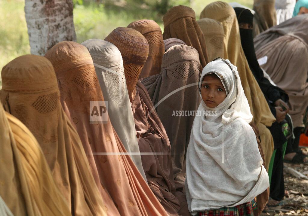 Muhammad Sajjad Women wait their turn to receive cash vouchers from an officer under the government's Ehsaas Emergency Cash program for families in need, in Peshawar, Pakistan, Tuesday, June 1, 2021. (AP Photo/Muhammad Sajjad)